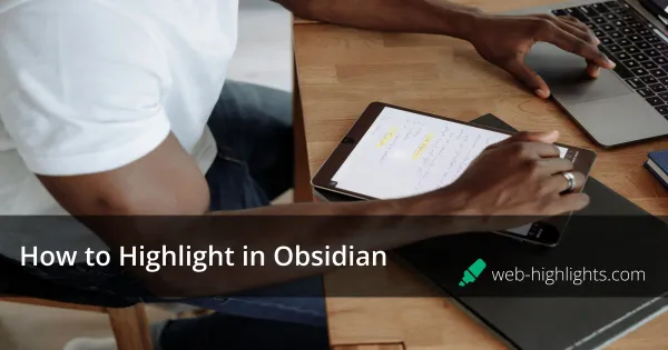 Person sitting at a desk using a tablet and laptop, with highlighted notes on the tablet screen.